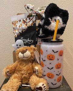 Festive Boo Box Halloween care package with treats, fuzzy socks, cup, Plush Bear, and optional flower arrangement, hand-delivered in Iowa City