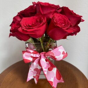 red roses in vase with ribbon